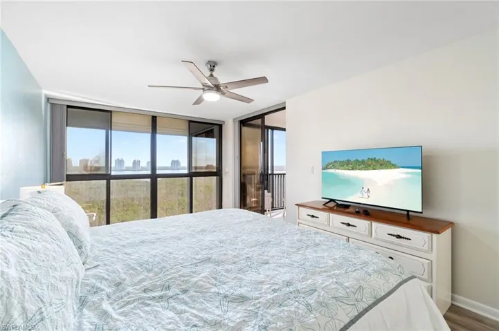Bedroom with floor to ceiling windows, ceiling fan, access to outside, and light wood-type flooring