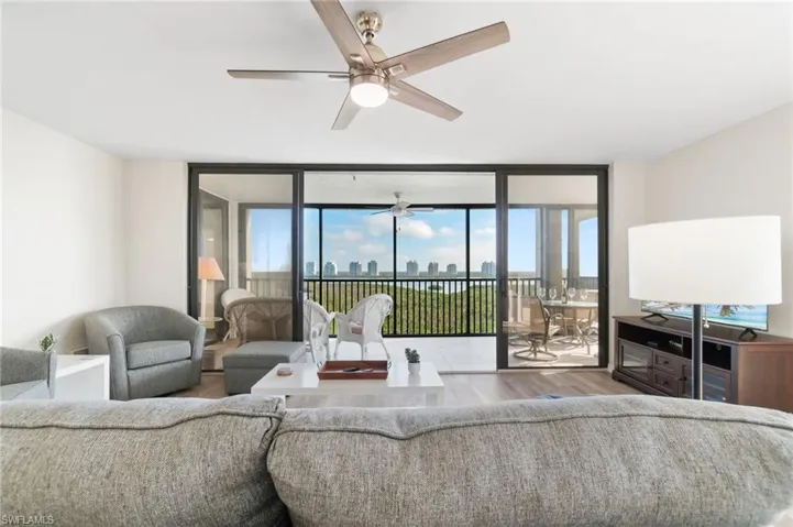 Living area featuring expansive windows, wood finished floors, and a ceiling fan