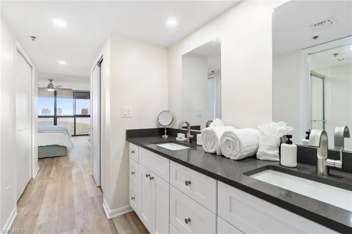 Ensuite bathroom featuring light wood-style floors, double vanity, ceiling fan, and recessed lighting