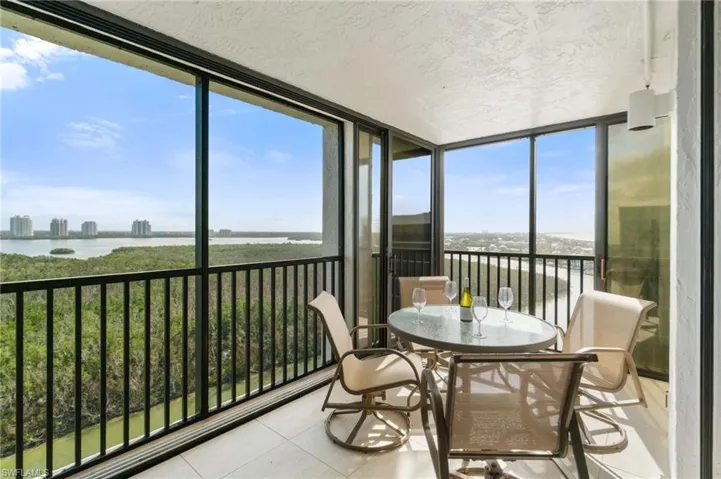 Sunroom featuring floor to ceiling windows, a water view, tile patterned flooring, and a textured ceiling