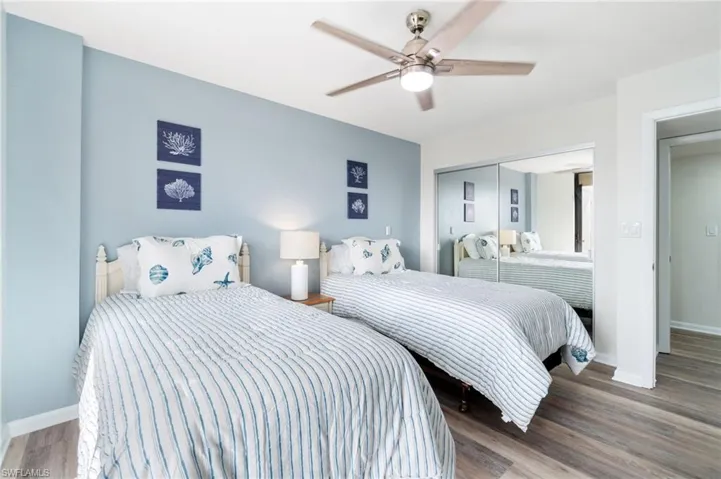 Bedroom with wood finished floors, ceiling fan, and a closet