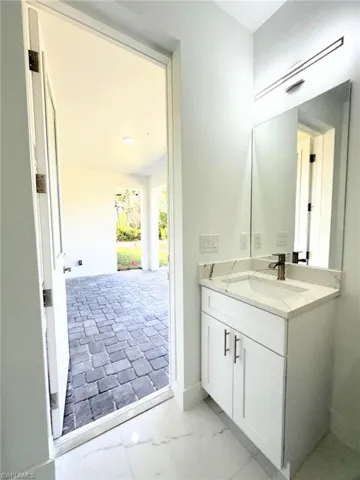 Bathroom with vanity and light marble finish flooring