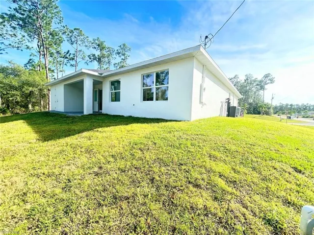 Back of house with a yard, stucco siding, and a patio area
