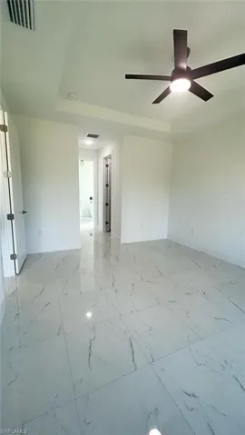 Spare room featuring light marble finish floors and baseboards