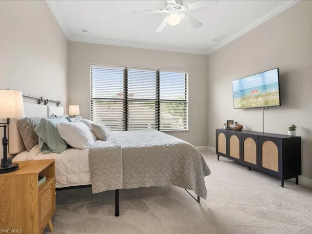 Bedroom featuring carpet floors, crown molding, and ceiling fan