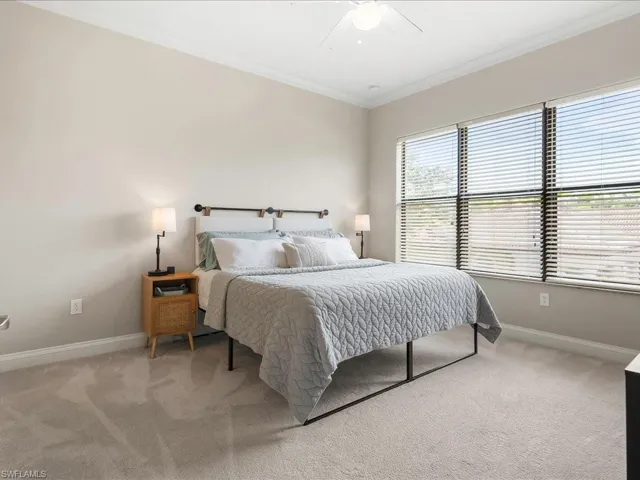 Carpeted bedroom featuring crown molding and a ceiling fan