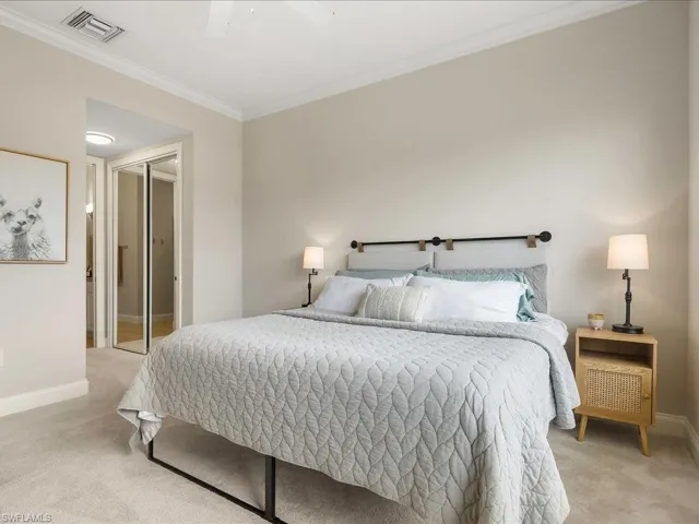 Carpeted bedroom with ornamental molding, a closet, and ceiling fan