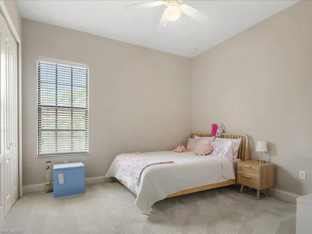 Carpeted bedroom featuring a closet and ceiling fan