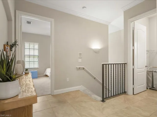 Stairway featuring tile patterned floors and crown molding