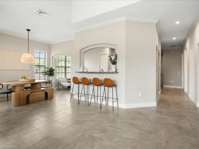 Dining area featuring crown molding and light tile patterned flooring