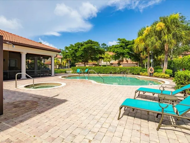 Community pool featuring a patio area, a community hot tub, and a sunroom