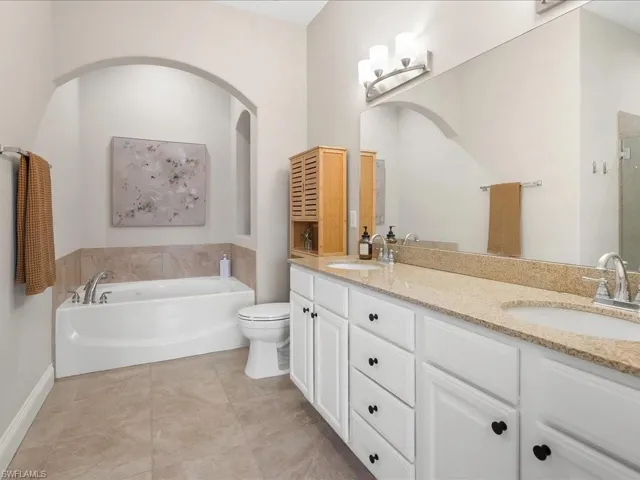 Bathroom featuring a garden tub, double vanity, light tile patterned flooring, and a shower stall
