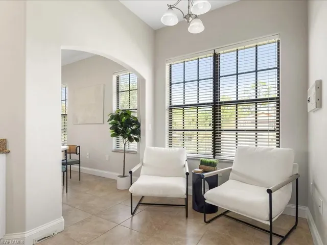 Living area with light tile patterned floors and a chandelier