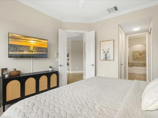 Bedroom featuring crown molding and ensuite bathroom