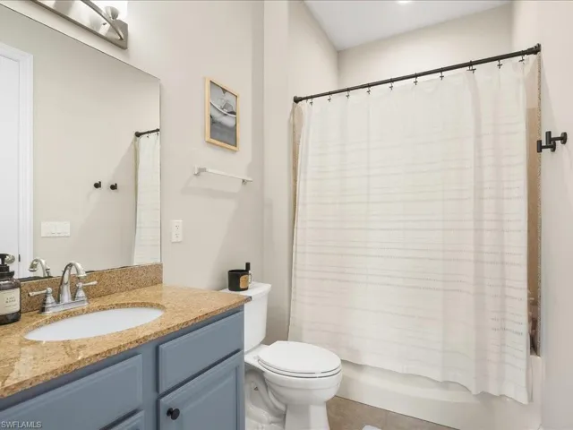Bathroom featuring shower / tub combo, tile patterned floors, and vanity