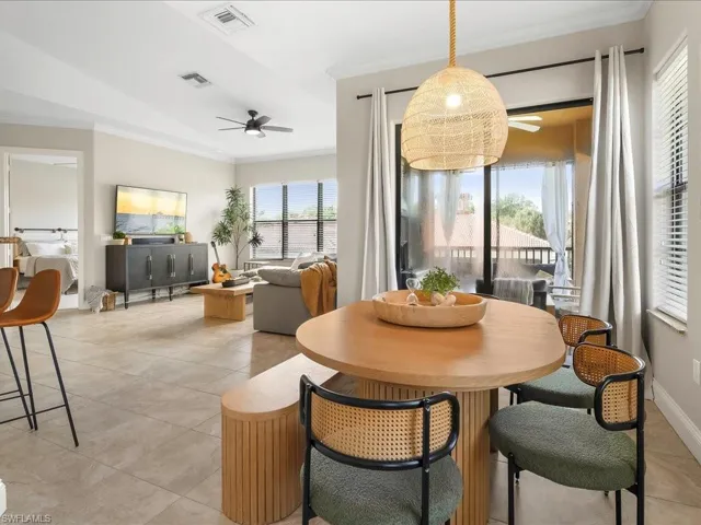 Dining space with crown molding, ceiling fan, and light tile patterned floors