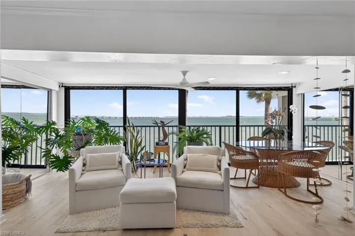 Expansive water views from a glass enclosed lanai with a ceiling fan