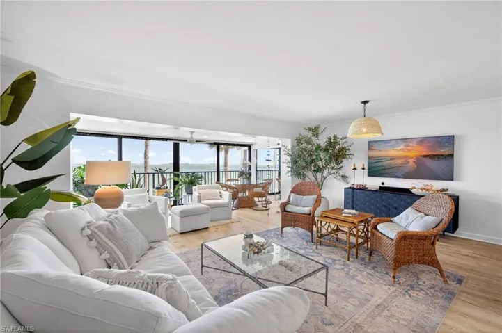 Open-concept living area featuring wood-finish flooring, a contemporary ceiling fan, and sliding glass doors
