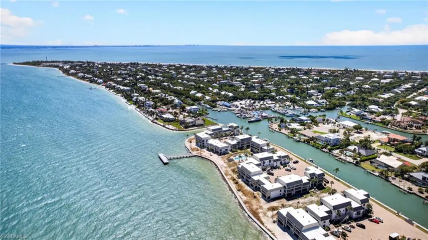 Coastal community featuring waterfront properties, a marina with multiple boats, and direct access to open water