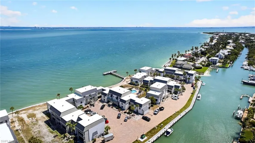 Waterfront property featuring direct bay access, a private dock, and a collection of multi-story residences