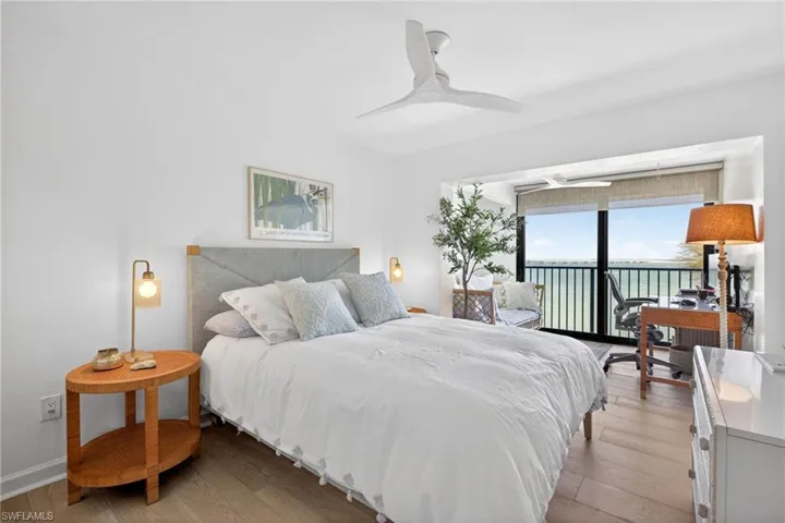 Bedroom with expansive windows, wood-finish flooring, and a ceiling fan