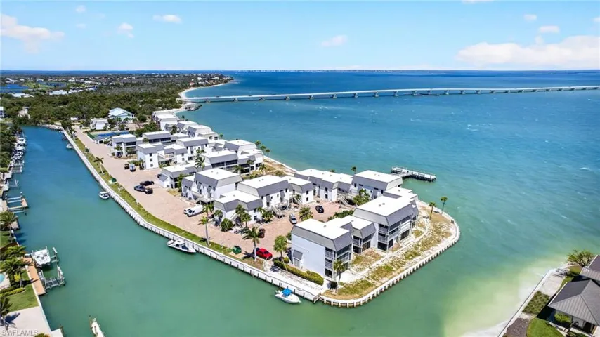 Waterfront community featuring multiple contemporary-style buildings, direct canal access, and a pier extending into the open water