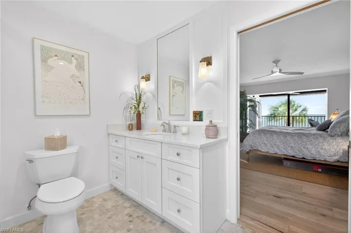 Primary Bathroom featuring a white vanity with a quartz-look countertop, undermount sink, and polished chrome faucet