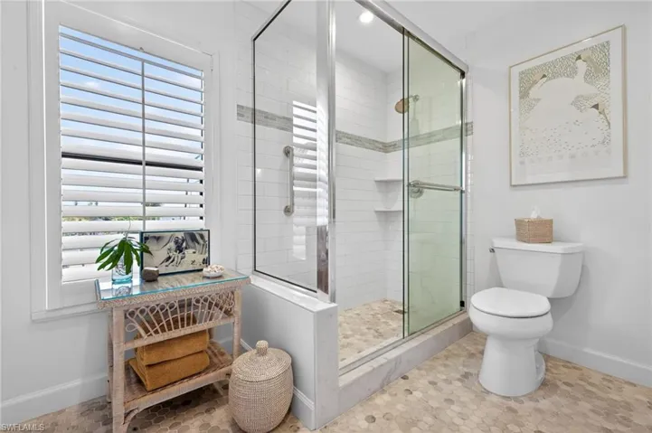 Shower enclosure with glass sliding doors, white subway tile surround, and a decorative tile accent band