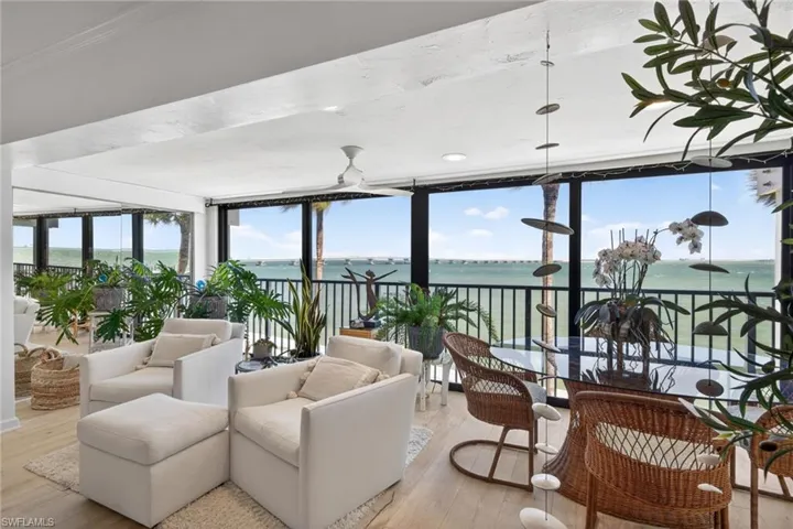 Spacious living area featuring expansive glass panels overlooking a body of water