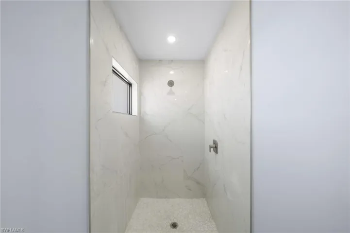 Full bathroom with a marble finish shower