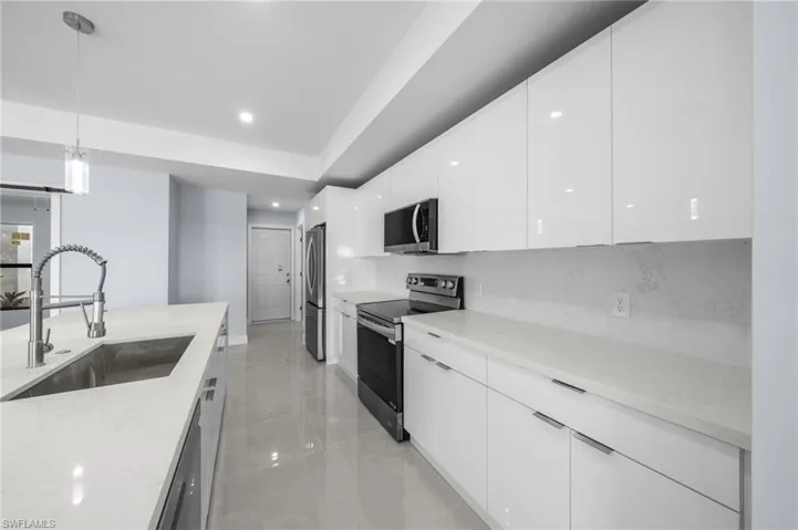 Kitchen with modern cabinets, pendant lighting, appliances with stainless steel finishes, white cabinetry, and recessed lighting