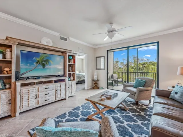 Tiled living room with ceiling fan and ornamental molding
