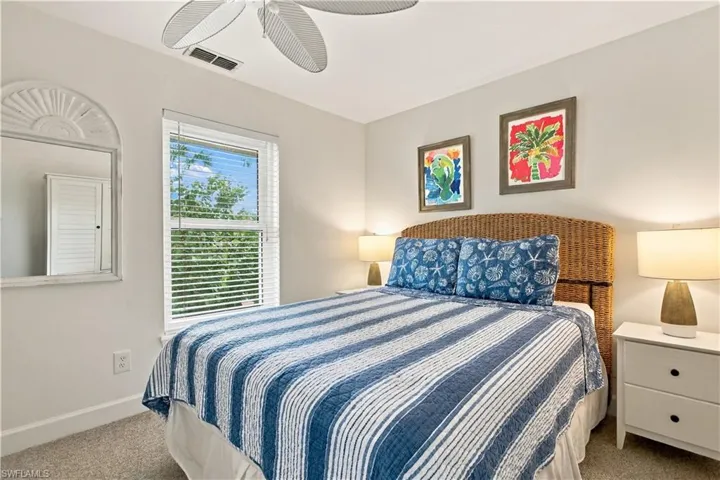 Window with blinds, ceiling fan, and wicker headboard