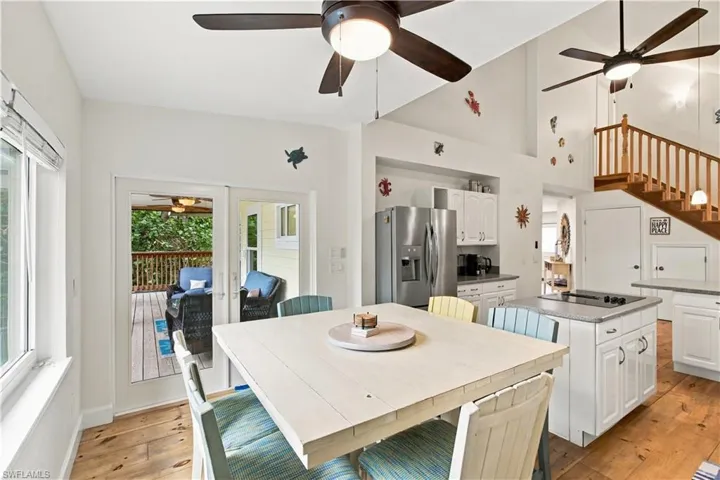 Kitchen with white cabinetry, stainless steel appliances, a center island with cooktop, and wood-finish flooring
