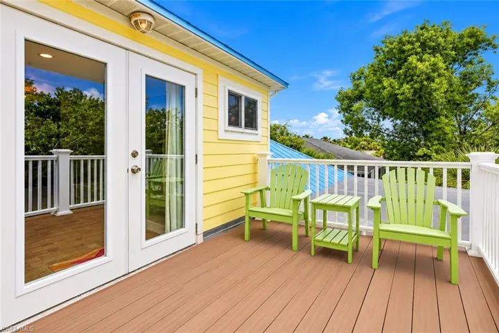 Exterior balcony featuring wood-finish decking and white railings