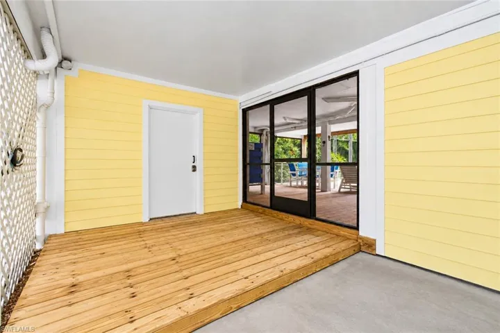 Outdoor deck featuring natural wood planks and direct access to a screened enclosure