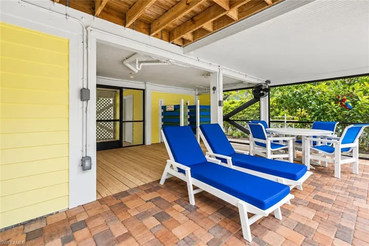 Covered outdoor living area featuring a paver patio and beadboard ceiling