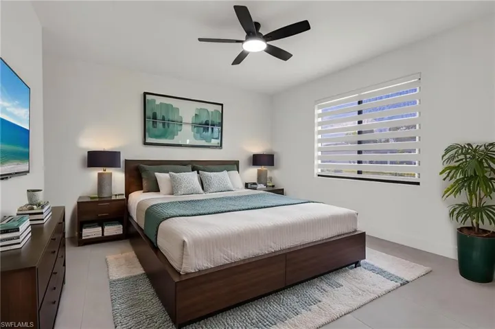 Bedroom with light tile patterned flooring, ceiling fan, and baseboards