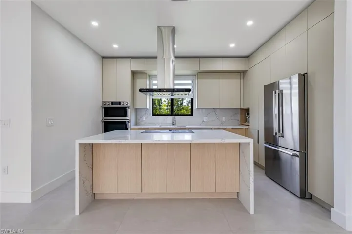 Kitchen with appliances with stainless steel finishes, backsplash, modern cabinets, a kitchen island, and recessed lighting
