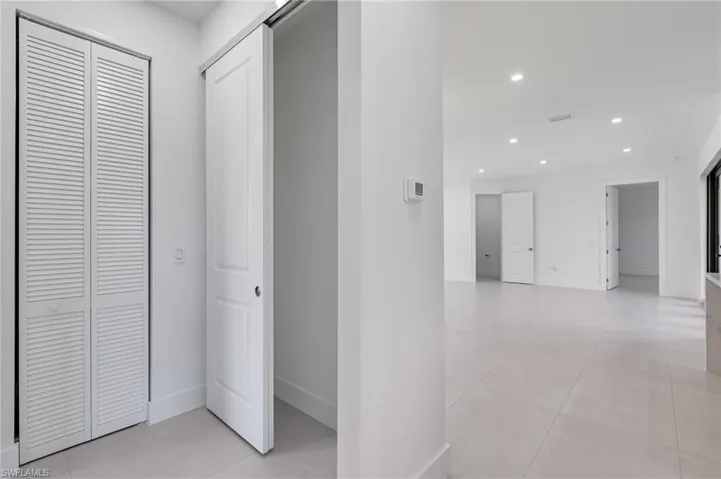 Hall featuring recessed lighting, baseboards, and light tile patterned flooring