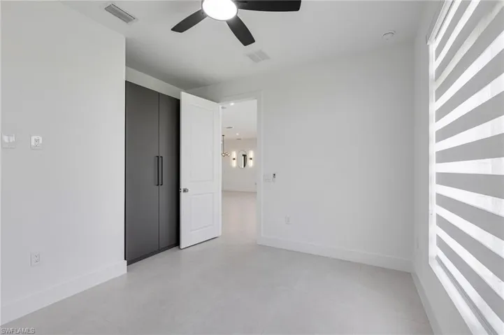 Unfurnished room with a ceiling fan and baseboards
