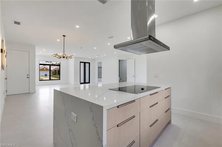 Kitchen with modern cabinets, black electric stovetop, island range hood, recessed lighting, and open floor plan