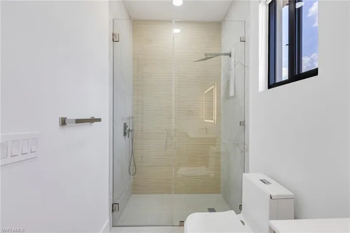 Bathroom with toilet, a stall shower, tile patterned floors, and recessed lighting