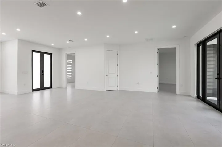 Empty room with french doors, light tile patterned floors, recessed lighting, and baseboards