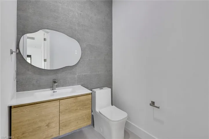 Bathroom featuring toilet, vanity, and tile patterned floors