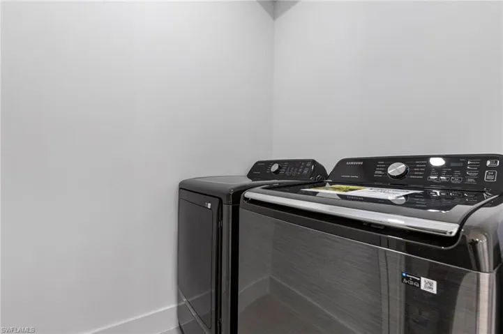 Laundry room featuring washing machine and dryer and baseboards