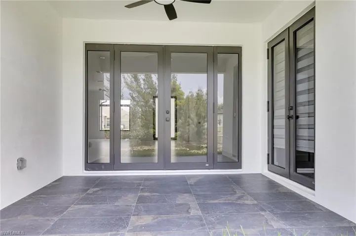 Doorway to property with french doors, ceiling fan, and stucco siding