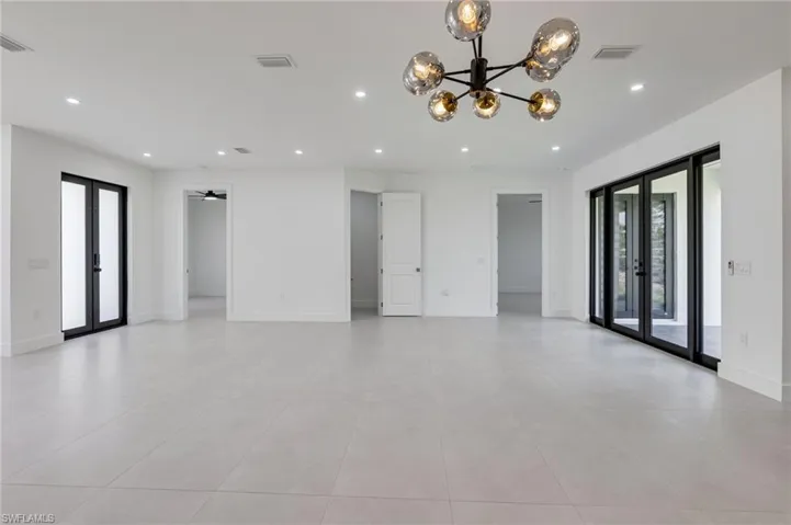Empty room with french doors, a chandelier, recessed lighting, light tile patterned flooring, and baseboards