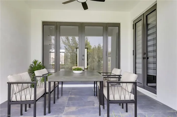 View of patio / terrace with french doors, outdoor dining space, and ceiling fan
