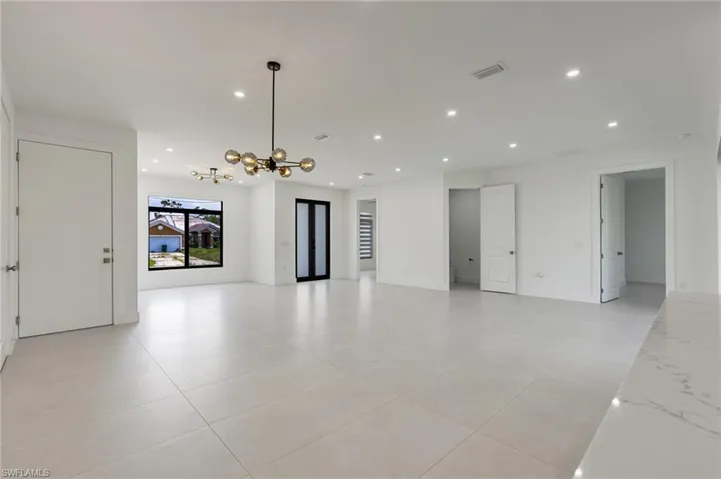 Unfurnished room with recessed lighting, a chandelier, light tile patterned flooring, and baseboards
